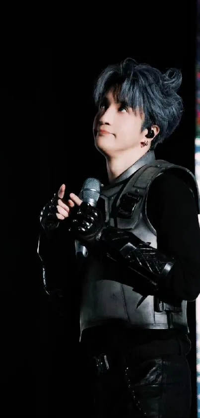 Dynamic performer on stage with striking gray hair and black attire.