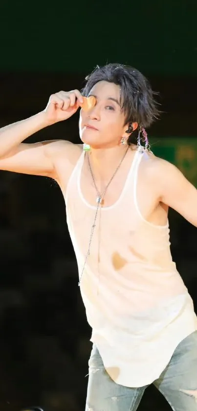 Performer dynamically posing on stage with mic.