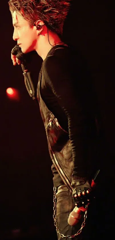 Musician passionately performing on stage with microphone under dramatic lighting.