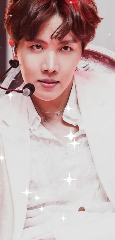 Dynamic performer in white outfit on stage with sparkling effects.