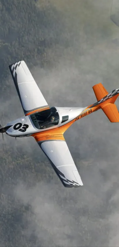 Airplane soaring above green forests and clouds.