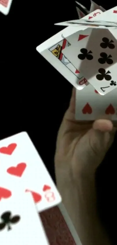 Floating playing cards on black background creating dynamic visual effect.