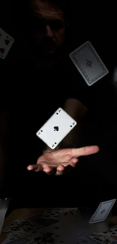 Floating playing cards in dramatic black background, hand in motion.