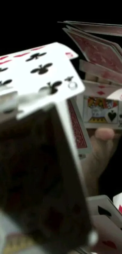 Dynamic playing cards in motion on a dark background wallpaper for mobile.