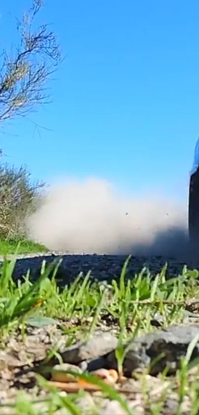 Dynamic racing scene with car on gravel road and clear blue sky.