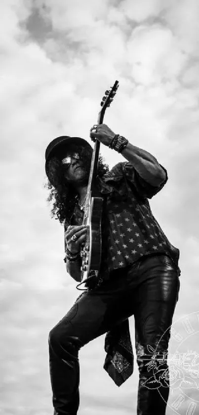 Guitarist in leather standing on sky backdrop