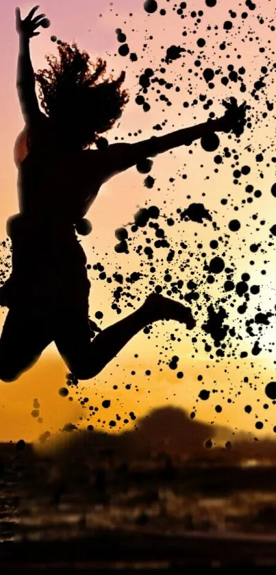 Silhouette jumping at beach with sunset background and ink splatters.