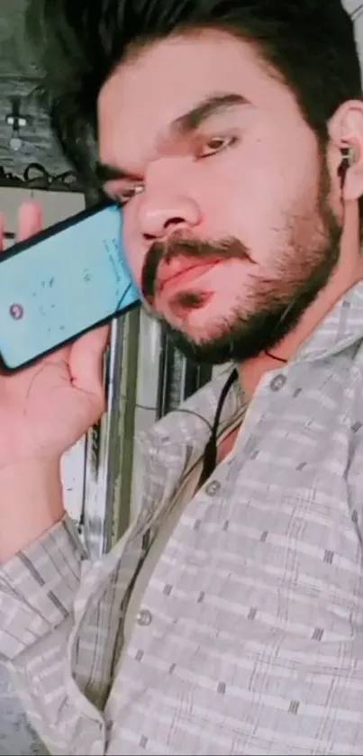 Person poses with smartphone against a light gray background.