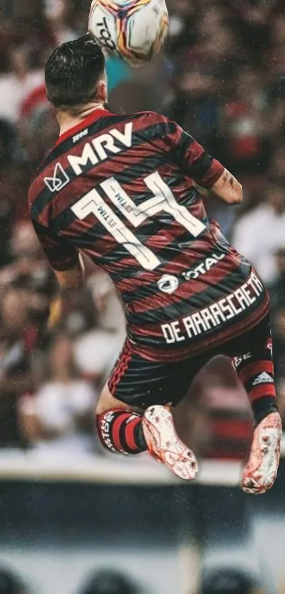 Soccer player in red jersey jumping midair during action-packed match.