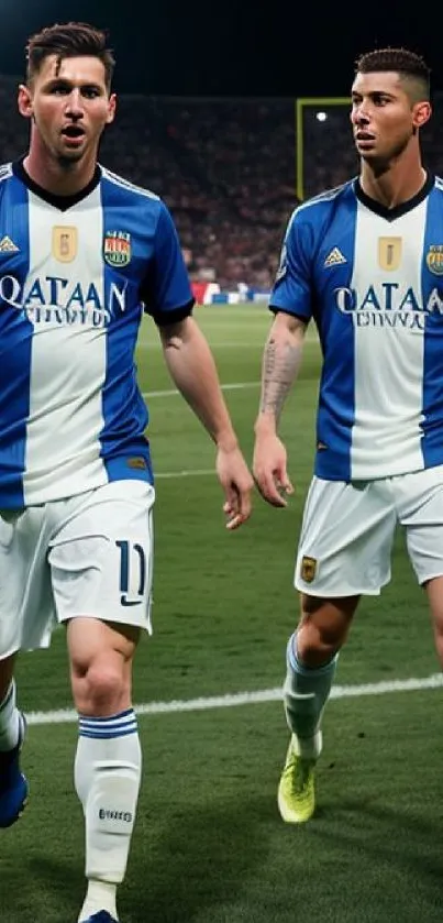 Two soccer players in blue uniforms on the field.