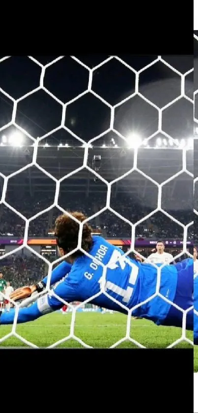 Soccer goalie diving to save ball in stadium.