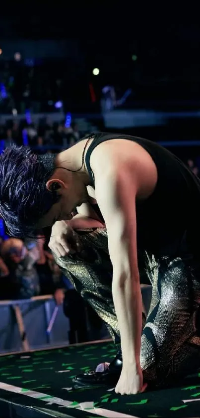 Dynamic performer kneels under stage lights.