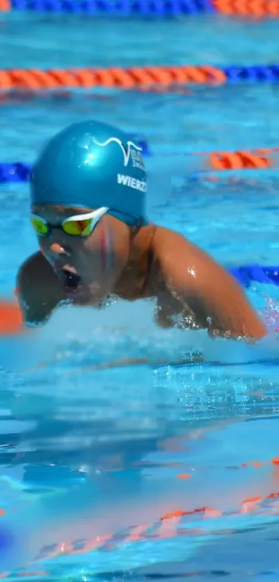 Swimmer in action with blue pool background, wearing blue swim cap and goggles.