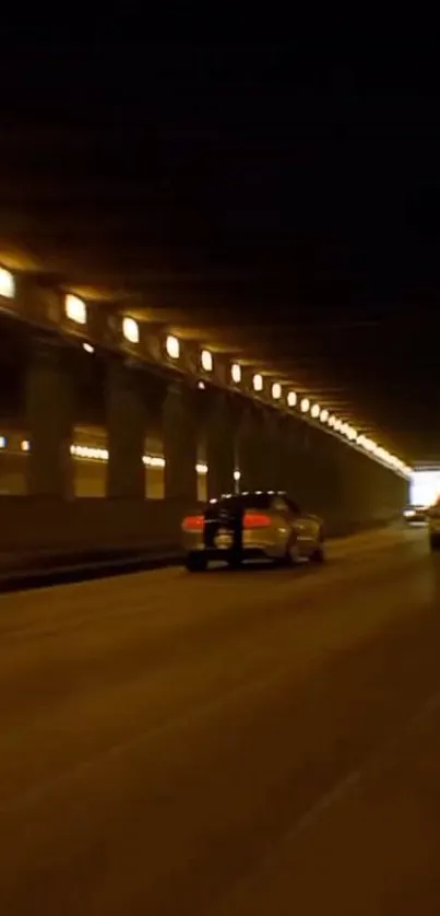 Cars speed through a well-lit tunnel at night, showcasing dynamic motion.