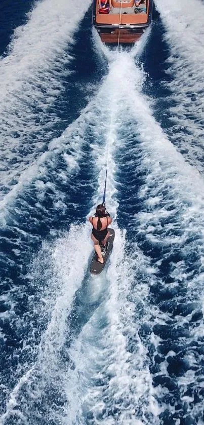 A wakeboarder pulled by a boat on open blue waters.