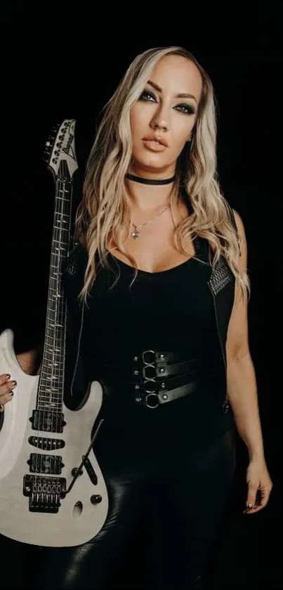 Woman holding a guitar against a dark background.