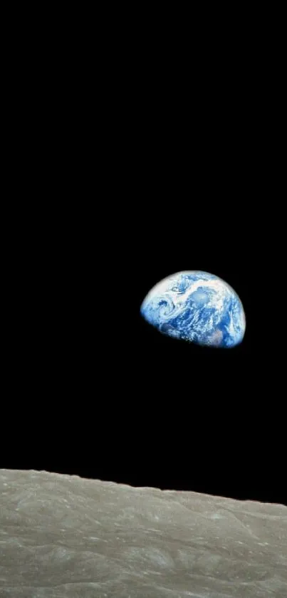 Earth rising over the lunar surface against the blackness of space.
