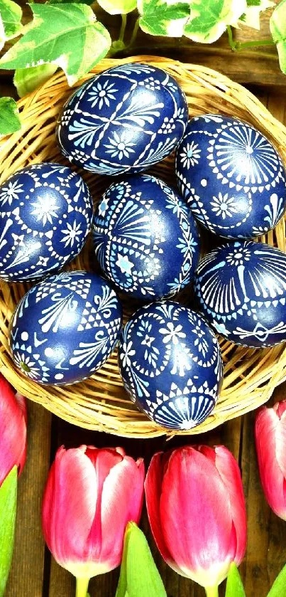 Basket of blue patterned eggs with pink tulips on a wooden background.