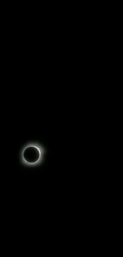 A minimalist wallpaper showing a glowing solar eclipse against a black background.