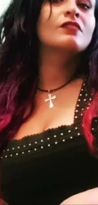 Edgy woman with dark attire and cross necklace, fashion-forward style.