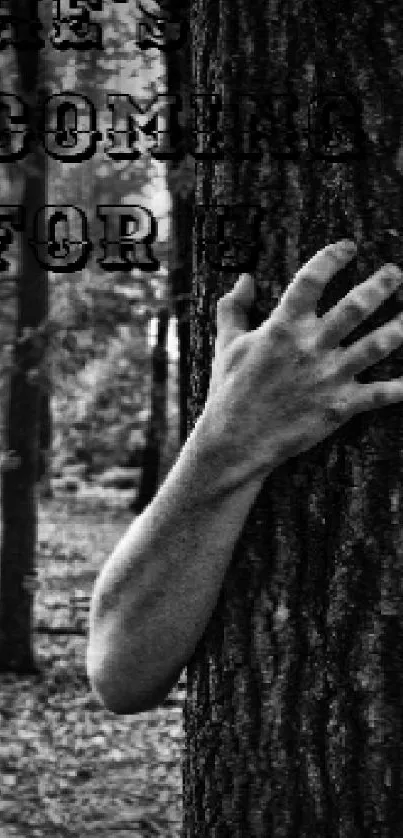 Spooky forest scene with hands grasping tree trunks in black and white.