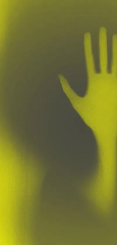 Eerie hand shadow on a yellow background wallpaper.