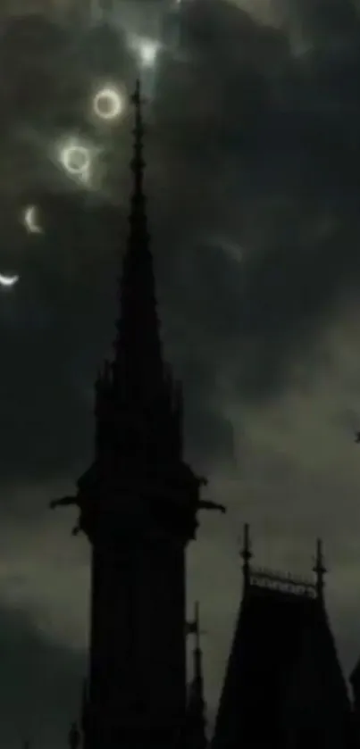 Gothic spire silhouetted against a cloudy, moonlit night sky.