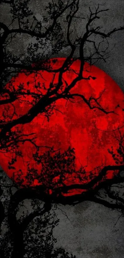 Mobile wallpaper featuring a red moon with silhouetted branches against a dark sky.