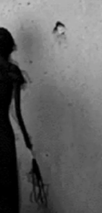 Shadowy dark figure against a grey wall, creating an eerie atmosphere.