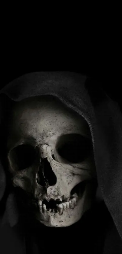 Eerie skull with dark hood on black background, perfect for gothic wallpapers.