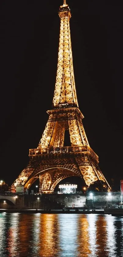 Eiffel Tower glowing at night by the Seine River, Paris.