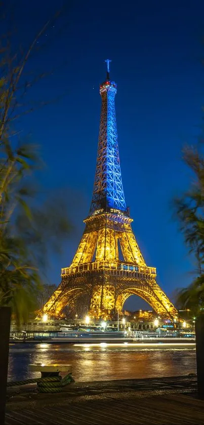 Eiffel Tower illuminated at night with deep blue sky in background.