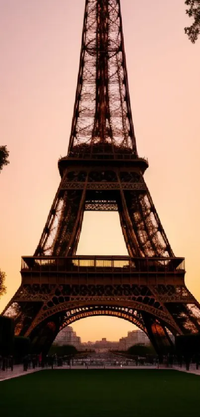 Eiffel Tower silhouetted against a peach sunset sky.