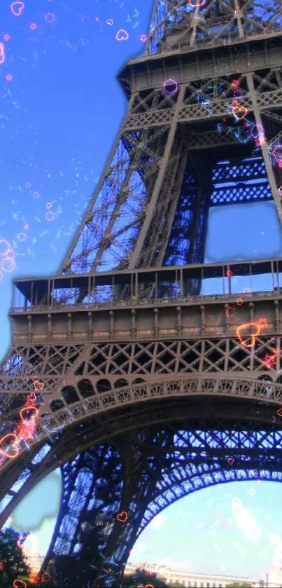 Eiffel Tower with heart sparkles against blue sky.