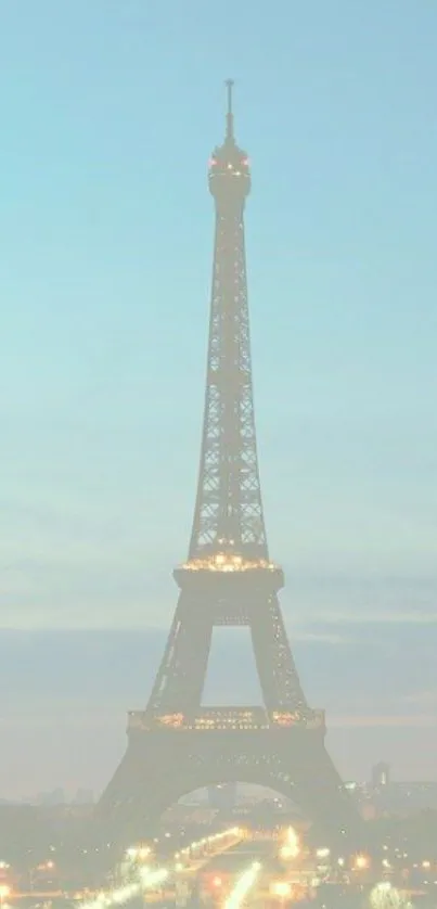 Eiffel Tower illuminated at dusk with a soft evening sky.