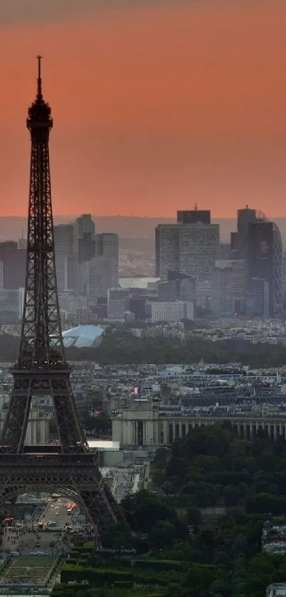 Eiffel Tower and Paris skyline at sunset, with buildings silhouetted against a warm orange sky.