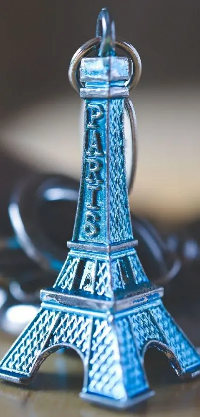 Blue Eiffel Tower keychain wallpaper on mobile screen.