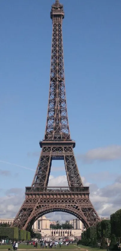 Eiffel Tower under a blue sky with clouds.