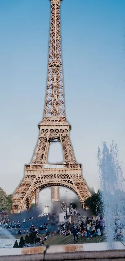 Eiffel Tower and fountain in Paris under blue sky.