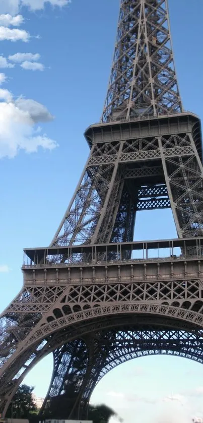 Eiffel Tower against a blue sky with clouds, capturing iconic Paris beauty.