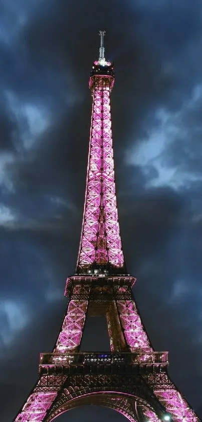 Eiffel Tower glowing in purple at night under a stormy sky.