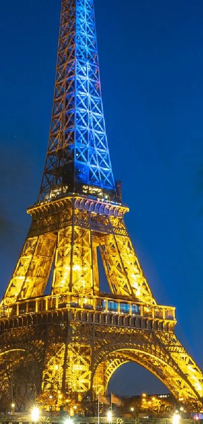 Eiffel Tower illuminated at night by the Seine in Paris.