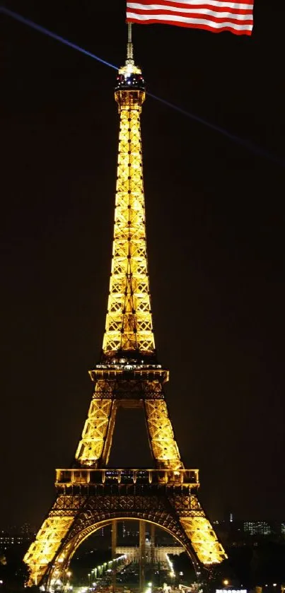 Eiffel Tower glowing at night with a flag atop.