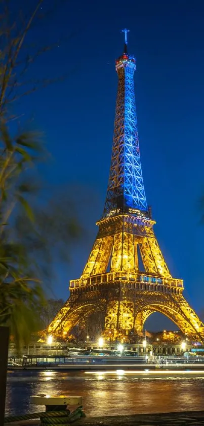 Eiffel Tower illuminated at night with a vibrant blue sky backdrop.