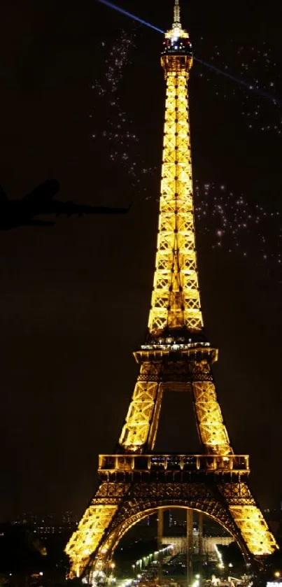 Eiffel Tower beautifully lit at night with a plane silhouette.