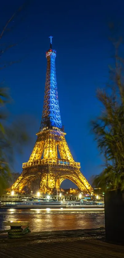 Eiffel Tower illuminated at night with city lights reflecting in the Seine.