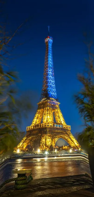 Eiffel Tower illuminated against a blue night sky with surrounding trees.