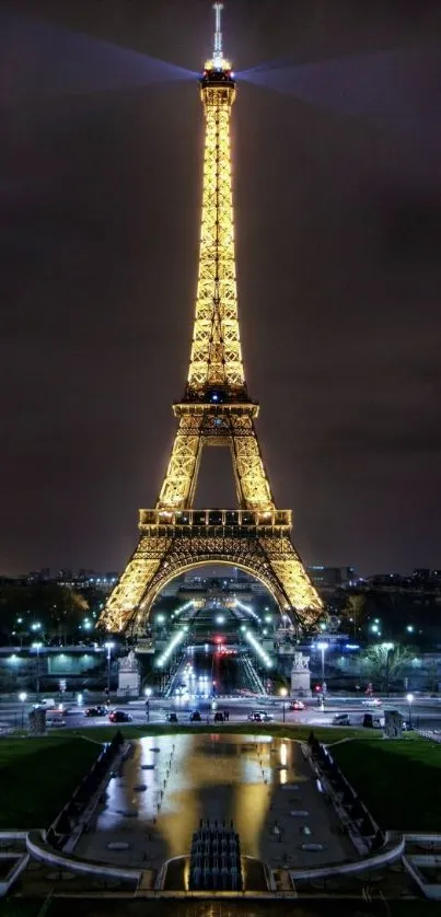 Eiffel Tower illuminated at night against a dark sky in Paris. Iconic travel scenery.