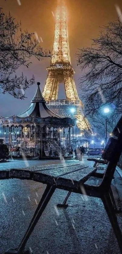 Night view of Eiffel Tower with glowing lights and a nearby bench in foreground.