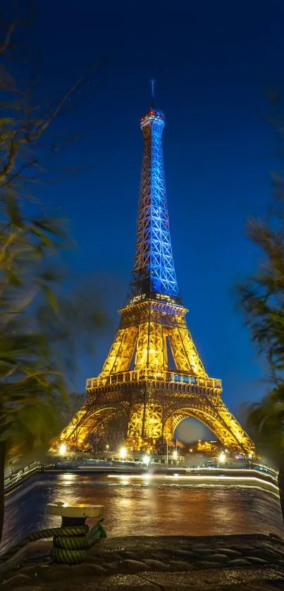 Eiffel Tower illuminated at night with dark blue sky.